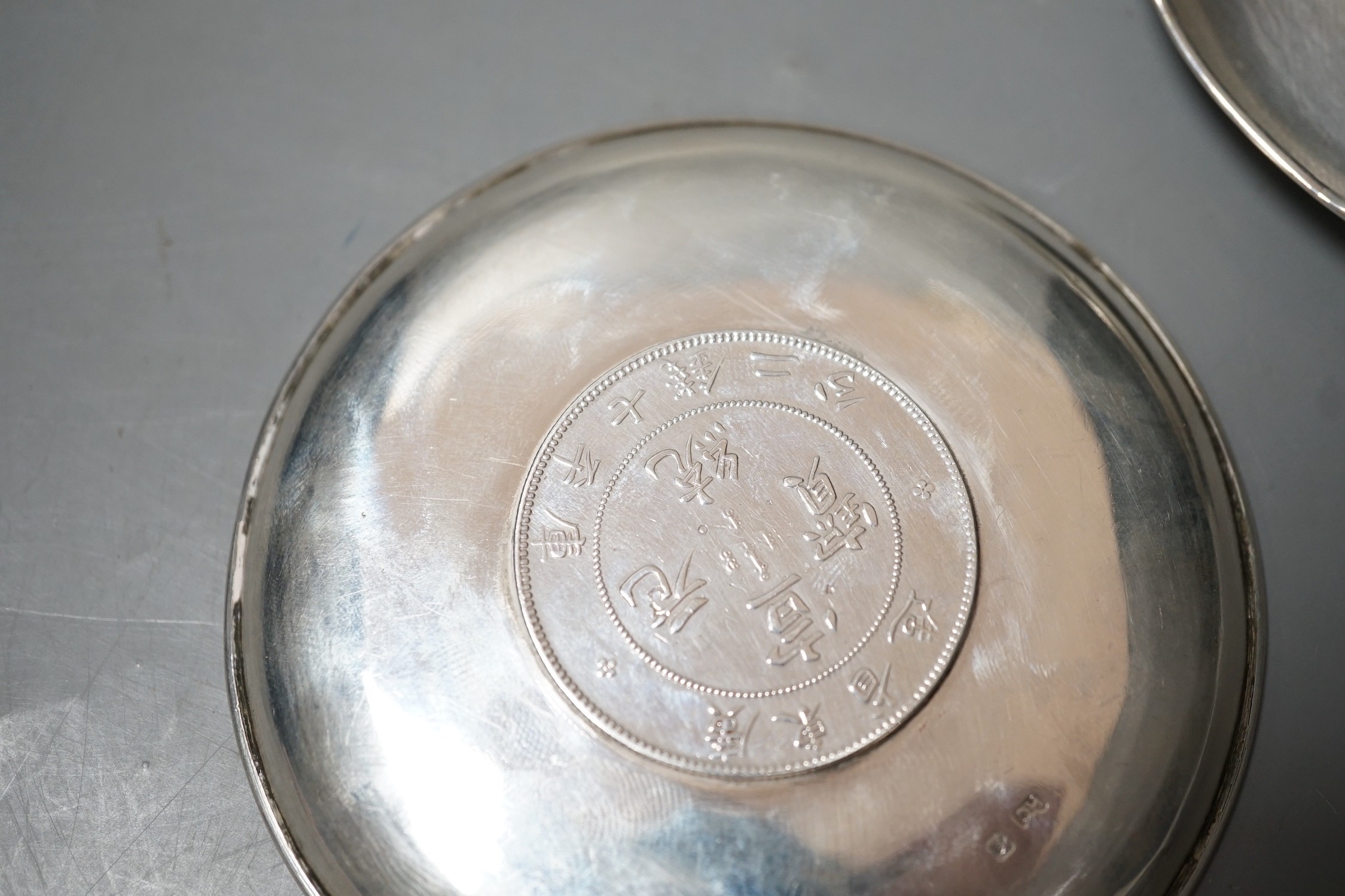 Three Chinese white metal dishes, each inset with coin, maker HC, 94mm, 196 grams gross.
